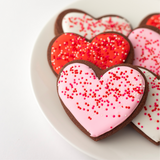 Chocolate heart-shaped Valentine's Day sugar cookies with red, pink and white royal icing and sprinkles