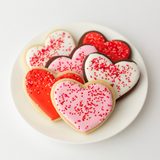 Vanilla and chocolate heart-shaped sugar cookies with red, pink and white royal icing and sprinkles