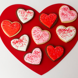 Vanilla and chocolate heart-shaped sugar cookies with red, pink and white royal icing and sprinkles