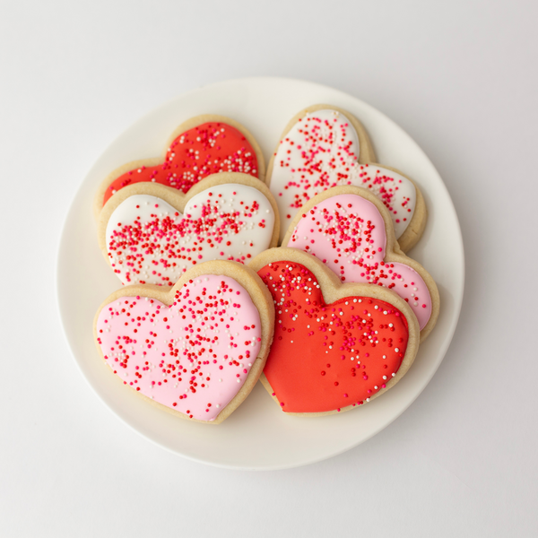 Vanilla heart-shaped Valentine's sugar cookies in pink, red and white royal icing with sprinkles