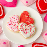 Vanilla heart-shaped Valentine's sugar cookies in pink, red and white royal icing with sprinkles