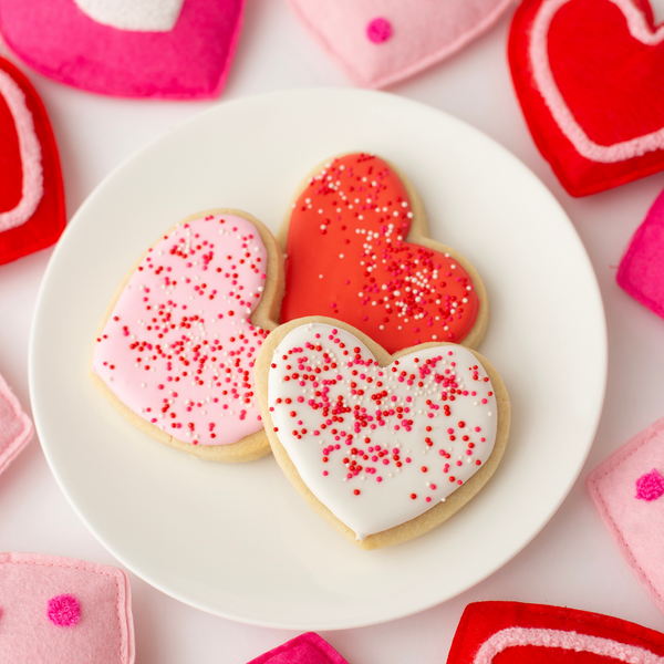 Vanilla heart-shaped Valentine's sugar cookies in pink, red and white royal icing with sprinkles