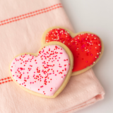 Vanilla heart-shaped Valentine's sugar cookies in pink, red and white royal icing with sprinkles